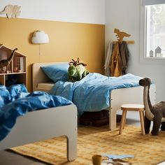 a child's bedroom with toys on the floor and in the background is a bed