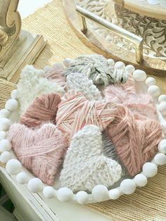 a white bowl filled with lots of different colored yarns on top of a table