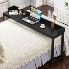 there is a bed with a white bedspread and a laptop on top of it