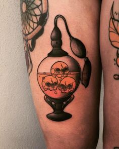 a woman's thigh with an image of skulls in a glass jar on it