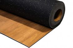 a rolled up yoga mat on top of a wooden floor with black and white speckles