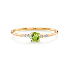 a yellow gold ring with an oval green stone and diamonds