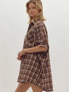 Stay cozy and stylish this fall with our oversized plaid flannel trimmed mini dress. Featuring a classic button-up shirt dress design, this piece is elevated with trim on the collar, half sleeves, and front pocket, giving it a warm, seasonal touch. The relaxed fit makes it perfect for layering or wearing solo for an effortlessly chic look. Available in rich olive and mocha tones, this dress is a must-have for fall outings. Available in olive and mocha. SIZE & FIT Model is 5'10" and wearing a siz Fall Daywear Collared Shirt Dress, Fall Shirt Dress With Spread Collar For Day Out, Fall Shirt Dress With Placket For Daywear, Fall Cotton Shirt Dress With Short Sleeves, Cotton Short Sleeve Shirt Dress For Fall, Fall Button-up Shirt Dress With Placket, Collared Plaid Dress For Work, Shirt Dress With Placket And Spread Collar For Fall, Oversized Fall Shirt Dress With Spread Collar