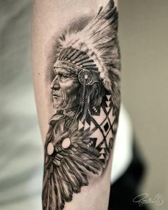 a man with a native american headdress tattoo on his arm and shoulder is shown