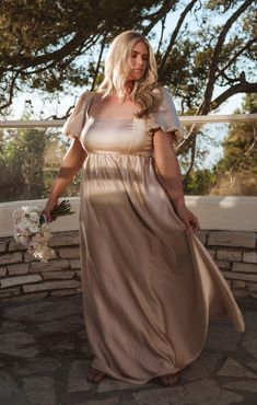 a woman in a long dress holding a bouquet