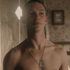 a shirtless man with no shirt standing in front of a mirror and looking at the camera