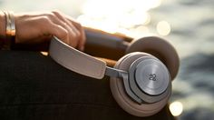 a close up of a person's headphones on their arm and the sun in the background