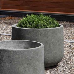 two cement planters sitting on top of gravel