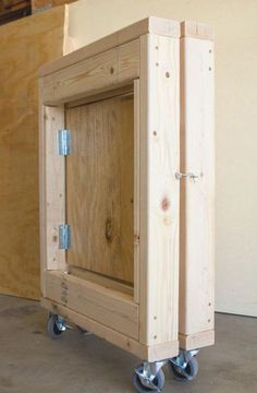 a wooden box sitting on wheels in a room