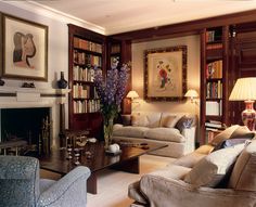 a living room filled with furniture and bookshelves next to a fire place in front of a fireplace