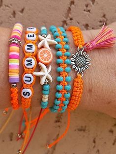 a woman's arm with four bracelets on it and an orange tassel