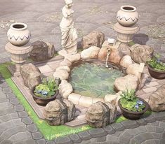 there is a fountain in the middle of some rocks and plants on the ground next to it