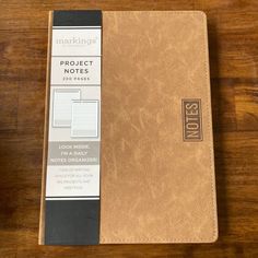 a brown notebook sitting on top of a wooden table