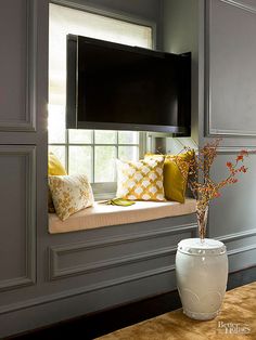 a vase with flowers in it sitting on a window sill next to a flat screen tv