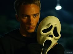 a man holding a white mask in front of his face