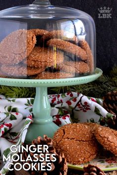 some cookies are under a glass dome on a table with pine cones and napkins