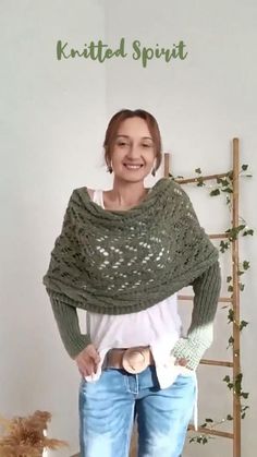 a woman standing in front of a white wall wearing a green knitted shawl