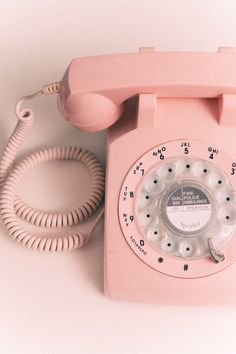 an old pink phone is sitting on the table