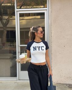 a woman is walking down the street with her handbag in her pocket and holding a bag