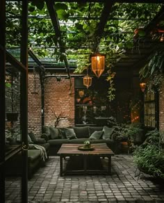 an outdoor living area with couches, tables and potted plants