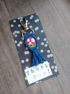 a keychain with a mushroom on it and a thank you tag attached to it