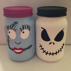 two jars with faces painted on them sitting next to each other