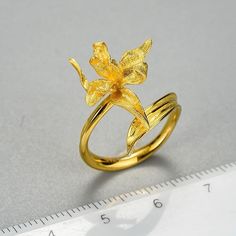 Introducing our exquisite Adjustable Gold Lily Rings, the epitome of elegance and versatility. Crafted with meticulous attention to detail, each ring features a delicate lily motif in radiant 18k gold plating, set upon a base of 925 sterling silver for lasting quality. Designed to fit comfortably on any finger, the adjustable band ensures a perfect fit for every wearer. Elevate your style with the timeless beauty of our Adjustable Gold Lily Rings, a stunning addition to any jewelry collection. Iris Ring, Lily Ring, Bijoux Art Nouveau, Motifs Perler, Iris Flower, Romantic Jewellery, Iris Flowers, Floral Jewellery, Flower Earrings Studs