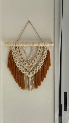 a wall hanging on the side of a door with tassels and beads attached to it