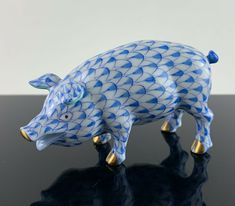 a blue and white pig figurine sitting on top of a black countertop