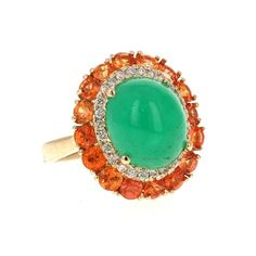 9.04 Carat Emerald Diamond and Orange Sapphire Cocktail Ring!  The most unique ring of all! A beautiful Cabochon Emerald sits in the center of the ring and is surrounded by a cluster of Orange Sapphires and Diamonds.  The carat weight of the stones are as follows:  Emerald = 6.55 carats (measurements of the Emerald are 10mm x 12mm) 16 Orange Sapphires = 2.20 carats 26 Round Cut Diamonds = 0.29 carats (Clarity: SI, Color: F)  The total carat weight of the ring is 9.04 carats.  The ring is set in Yellow Gold Multi-stone Cabochons Fine Jewelry, Yellow Gold Multi-stone Cabochons For Fine Jewelry, Oval Multi-stone Emerald Gemstones, Luxury Multi-stone Oval Cabochons, Formal Multi-stone Oval Cabochon Gemstones, Yellow Gold Multi-stone Oval Cabochon Gemstones, Dazzling Oval Multi-stone Cluster Ring, Dazzling Oval Multi-stone Gemstones, Oval Multi-stone Gemstones