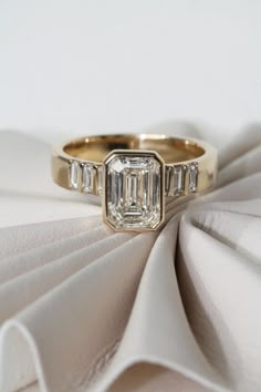 a diamond ring sitting on top of a white cloth