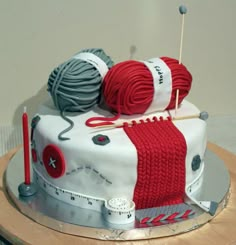 a cake decorated with yarn and knitting needles