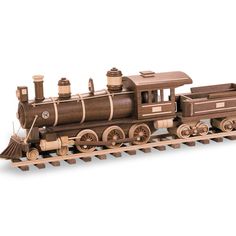 a wooden model of a steam engine train on tracks with wood trimmings and wheels