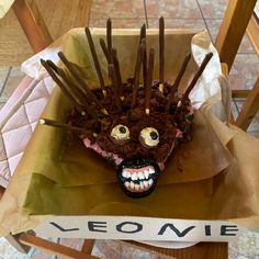 a cupcake with chocolate sticks sticking out of it's face on a chair