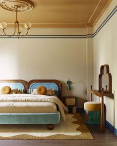 a bedroom with a bed, dresser and rug in the middle of it on top of a hard wood floor