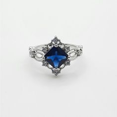 a ring with a blue stone in the center and filigrees around it