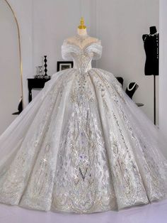 a white wedding dress with silver sequins on the skirt is displayed in front of a mannequin