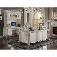 an elegant bedroom with white furniture and chandelier hanging from the ceiling, along with a fireplace