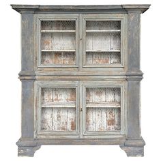 an old wooden cabinet with glass doors on the front and bottom shelves, painted white