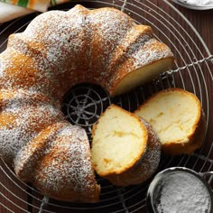 a bundt cake on a cooling rack with powdered sugar and two slices cut out