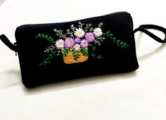 a black purse with flowers painted on it