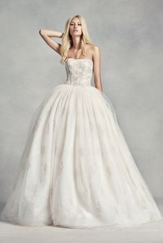 a woman in a wedding dress posing for the camera with her hand on her head