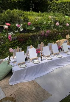 the table is set up with easels and plates for an art party in the garden