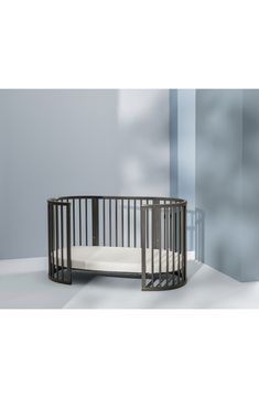 a baby crib in the corner of a room with blue walls and white flooring