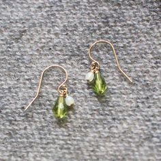 A lovely green teardrop and a little honeydew-colored bead are suspended from each 14k French gold-filled earwire on these sweet little earrings. Handmade in Seattle, WA.+ measures just over .75" from the top curve of the earwire to the base of the teardrop+ made with gold-filled earwires & glass beads+ packaged in a lovely small gift box tied with black ribbonLove purple jewelry? Shop more here: http://etsy.me/2thTQ4DLooking for more earrings? See more here: http://etsy.me/2thQnDc Green 14k Gold-filled Dangle Earrings, Green 14k Gold Filled Dangle Earrings, Hypoallergenic Green Teardrop Jewelry, Green Teardrop Drop Earrings Nickel Free, Green Nickel-free Teardrop Drop Earrings, Green Nickel-free Teardrop Earrings, Hypoallergenic 14k Gold-filled Teardrop Dangle Earrings, Green Dainty Dangle Earrings, Everyday Green Teardrop Pendant Jewelry