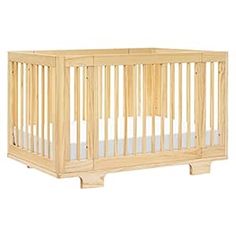 a small wooden crib with white sheets on the bottom and side rails, in front of a white background