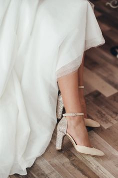 a woman in high heels is sitting on the floor with her wedding dress and shoes