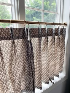 the curtains are lined up in front of the window sill, ready to be hung