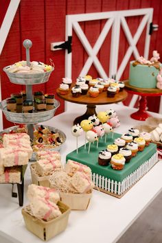 a table topped with lots of cakes and cupcakes on top of it's sides