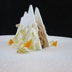 a white plate topped with food covered in icing and orange peels on top of it